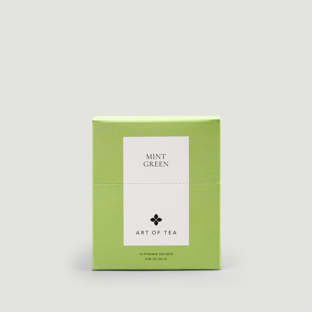 Green box of 'Mint Green' tea from 'Art of Tea' on a light gray background