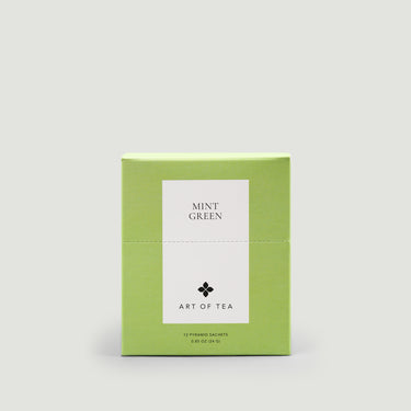 Green box of 'Mint Green' tea from 'Art of Tea' on a light gray background