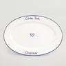 A white ceramic serving platter with blue rim and text that reads 'Casa Tua' on the top and 'Cucina' on the bottom, with a heart symbol between the two words.