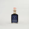A bottle of Balsamic Vinegar of Modena with a label indicating it is an aged vinegar suitable for dressing salads, vegetables, and meats.