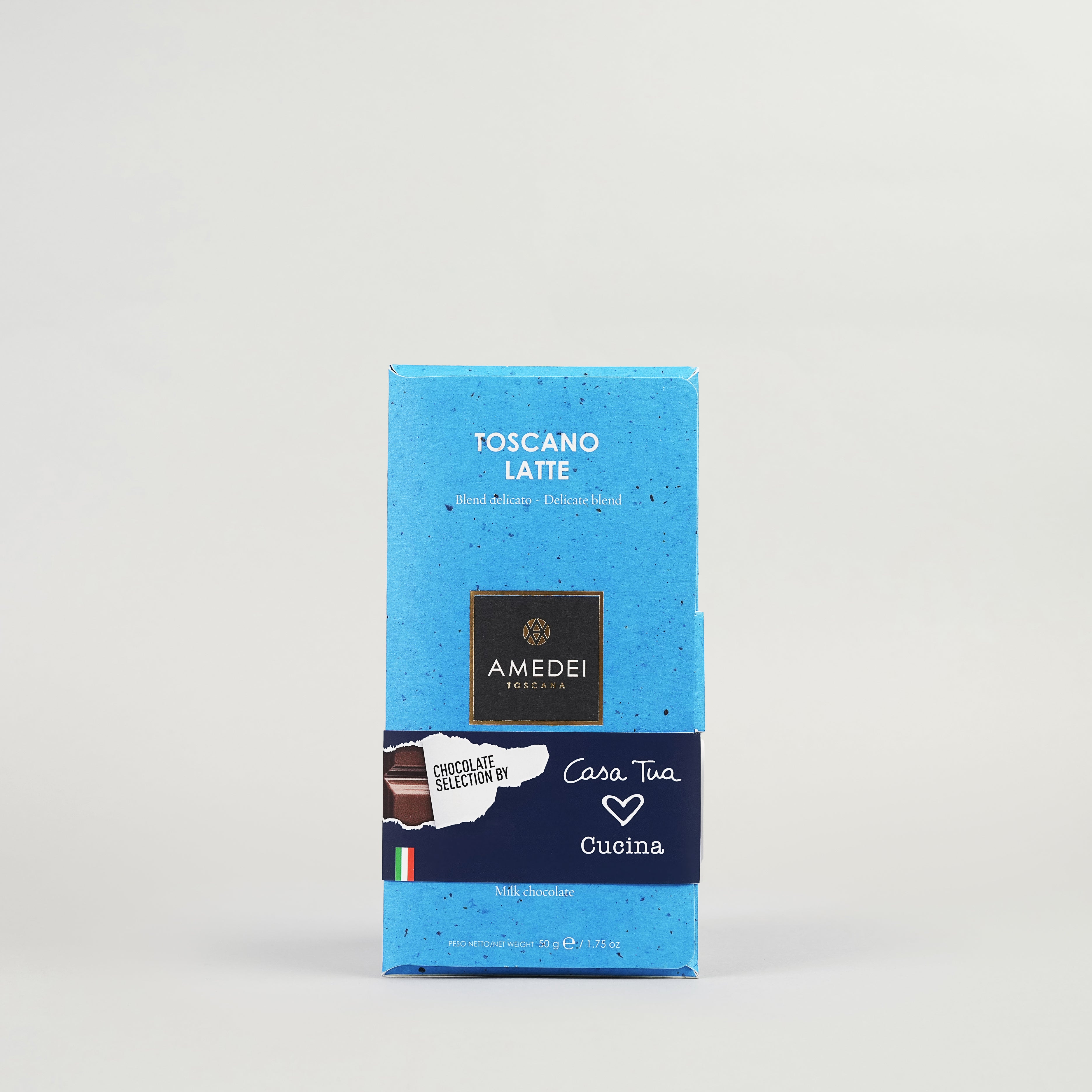 A blue box of Amedei Toscano Brown milk chocolate with Italian text and branding on the packaging.
