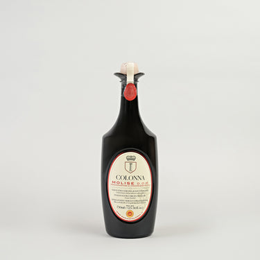 A bottle of Colonna DOP MOLISE Extra Virgin Olive Oil with a label indicating it is 750 ml. The bottle is upright and has a dark tint with a red cap.