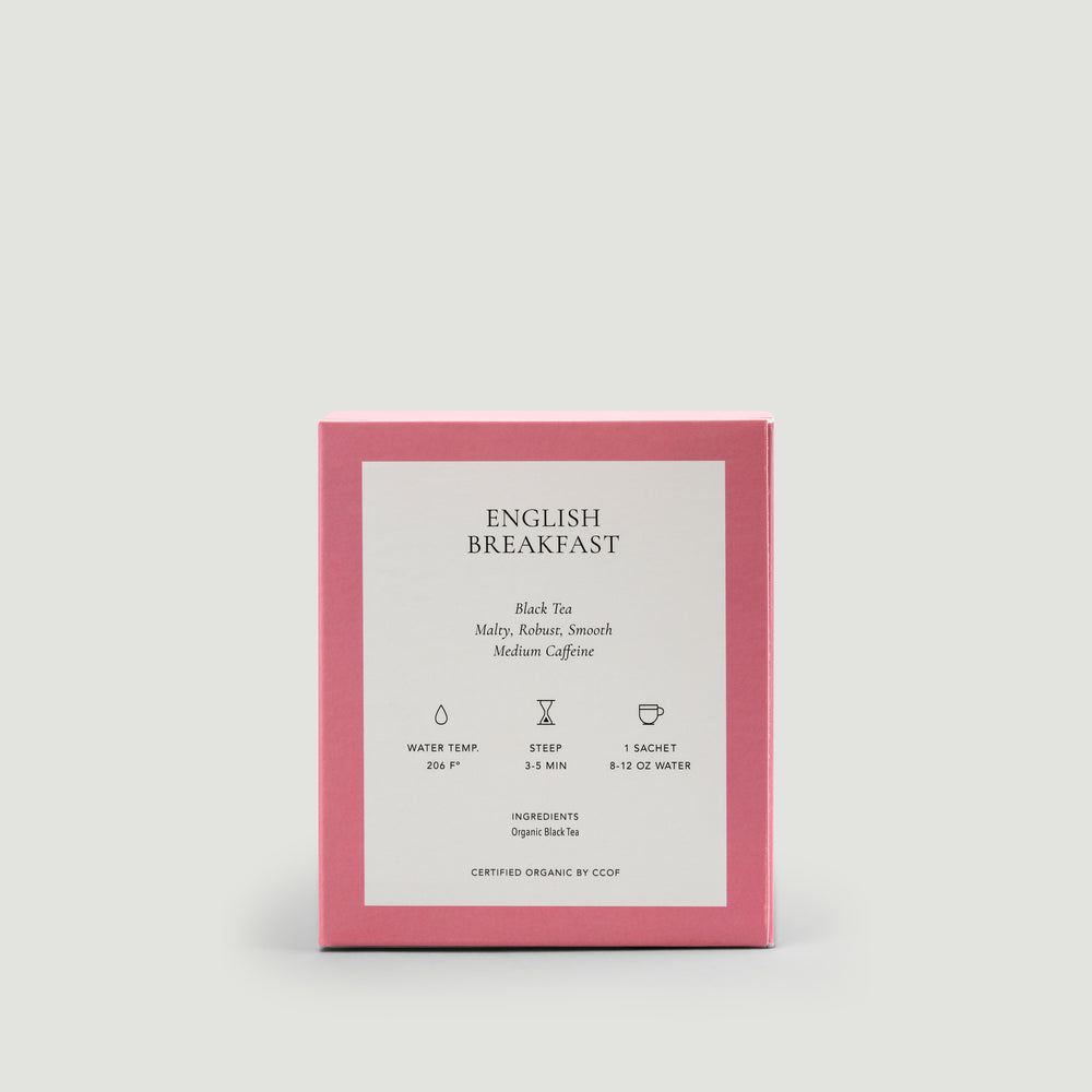 Pink packaging of English Breakfast tea with white label on a light gray background