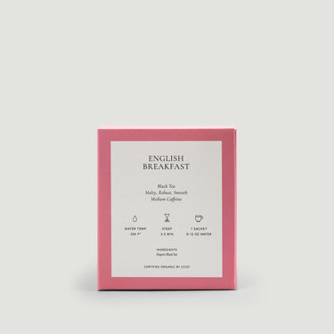 Pink packaging of English Breakfast tea with white label on a light gray background