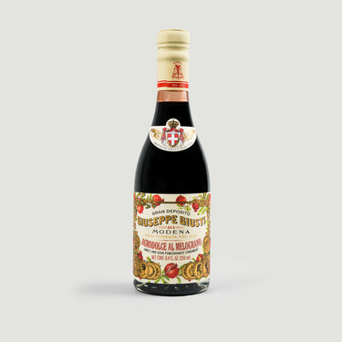 Bottle of Giuseppe Giusti Modena with decorative label on a white background