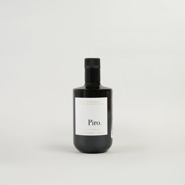 A bottle of Piro cooking oil with a white label and black text, set against a plain background.