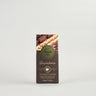 A packaged Venchi Milk Gianduja Bar, showing the bar and whole hazelnuts, with branding and product information on the label.